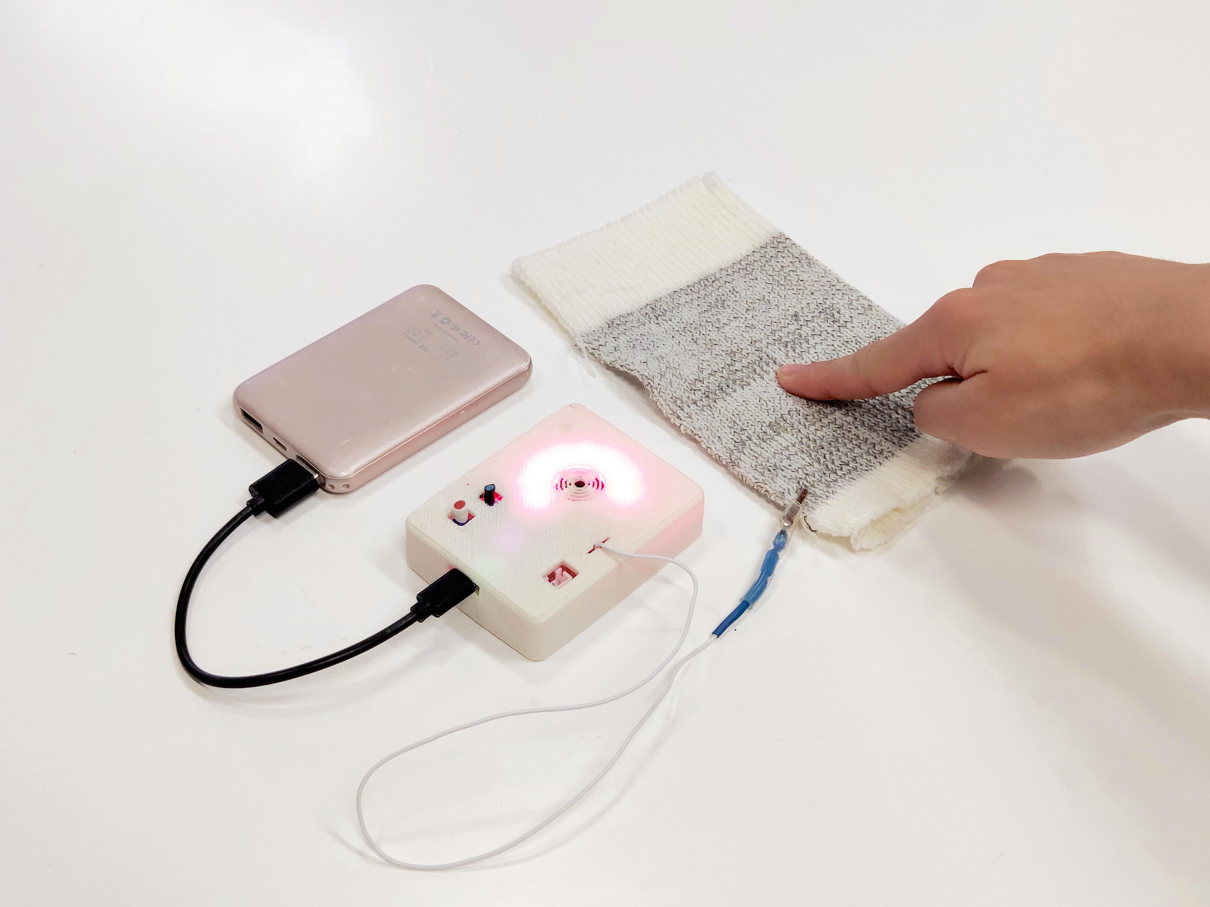 Hand testing a textile sensor connected to an electronic meter