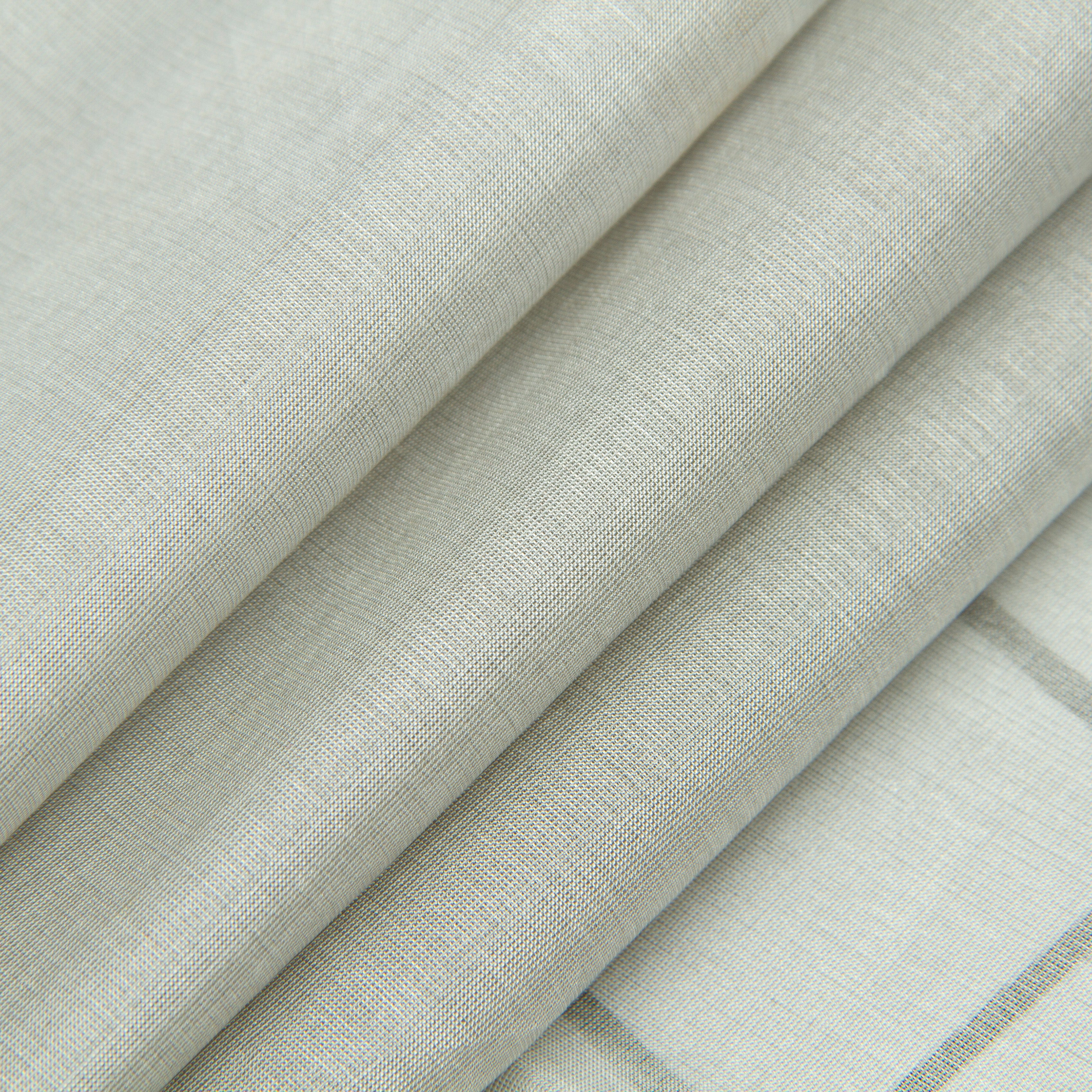 Folded rolls of pale silver-and-natural-fiber fabric