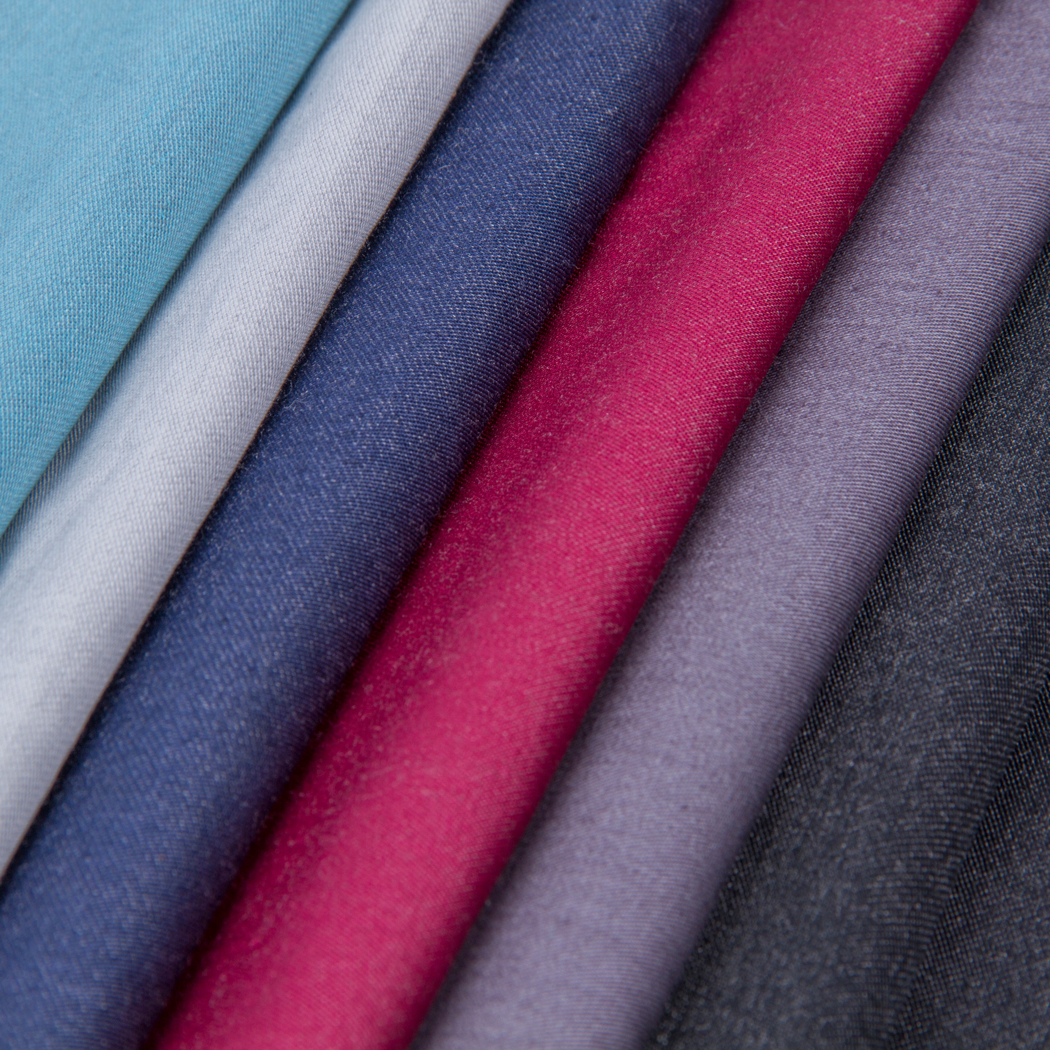 Rolls of stainless-steel-blend fabric in black, blue, red, and gray