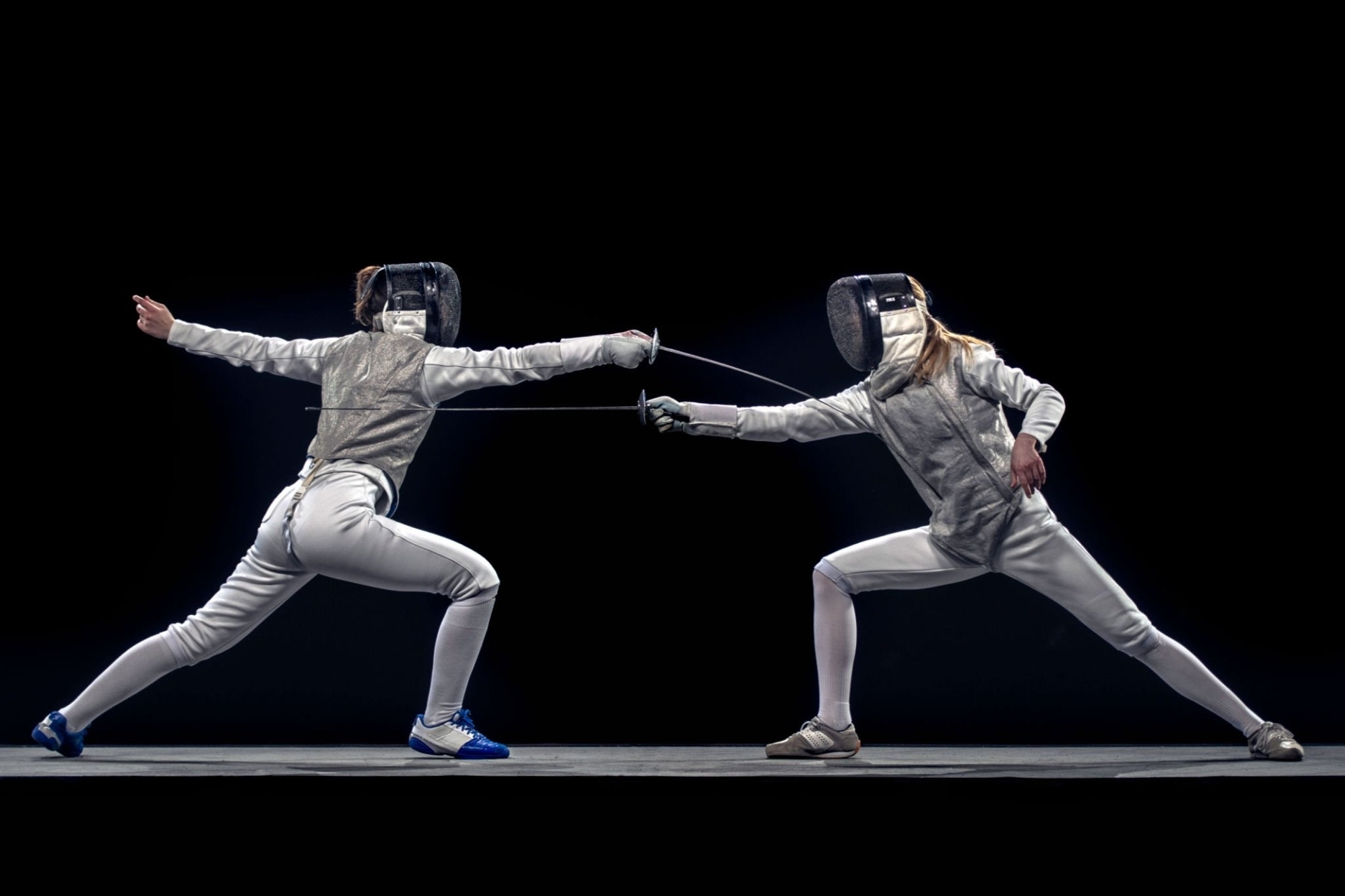 Two fencers lunging toward each other on a dark background