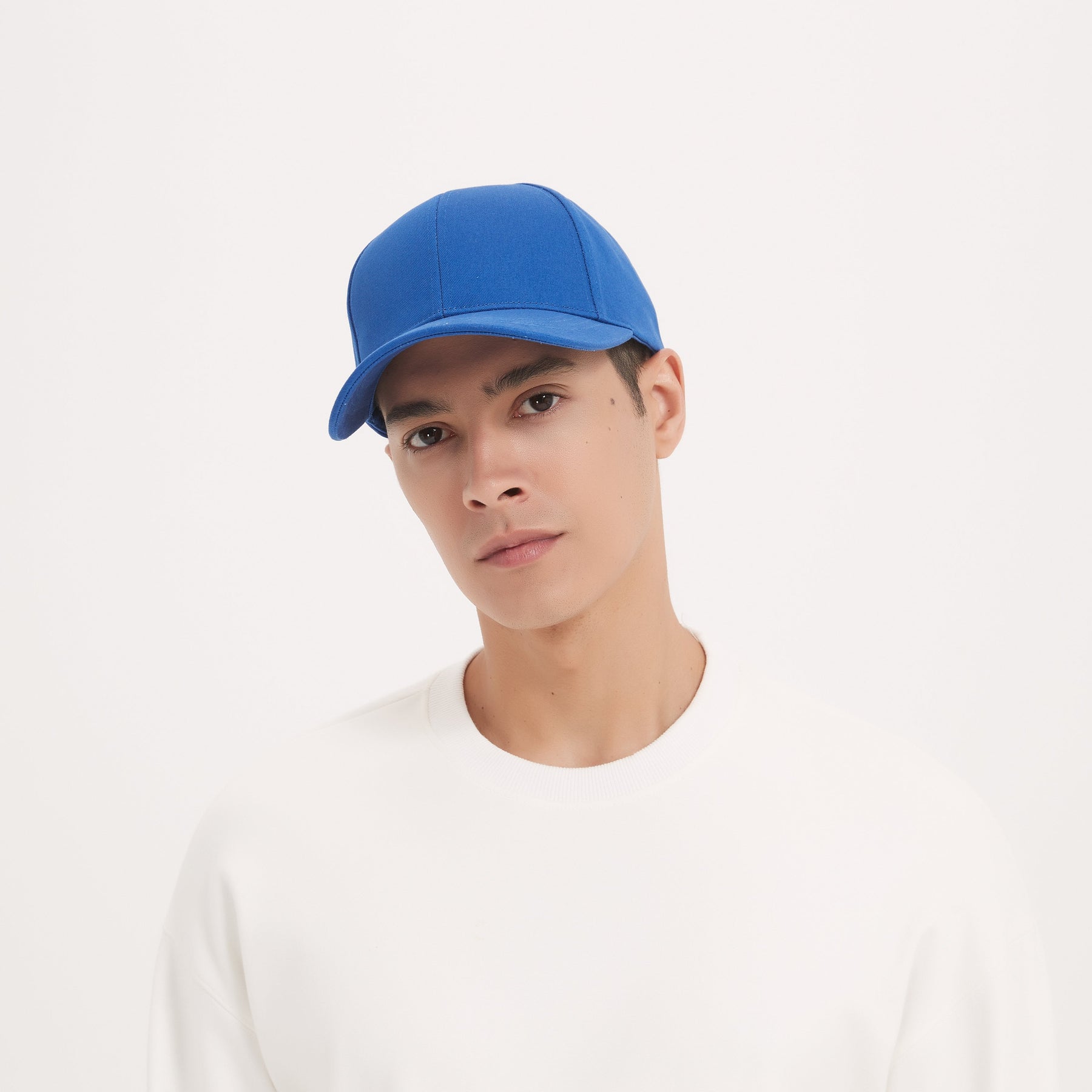 Front view of a male model wearing a royal blue color RF Shield Faraday Cap to protect his head