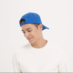 A male model is happy about wearing his EMF Shielding Hat in Royal Blue color.