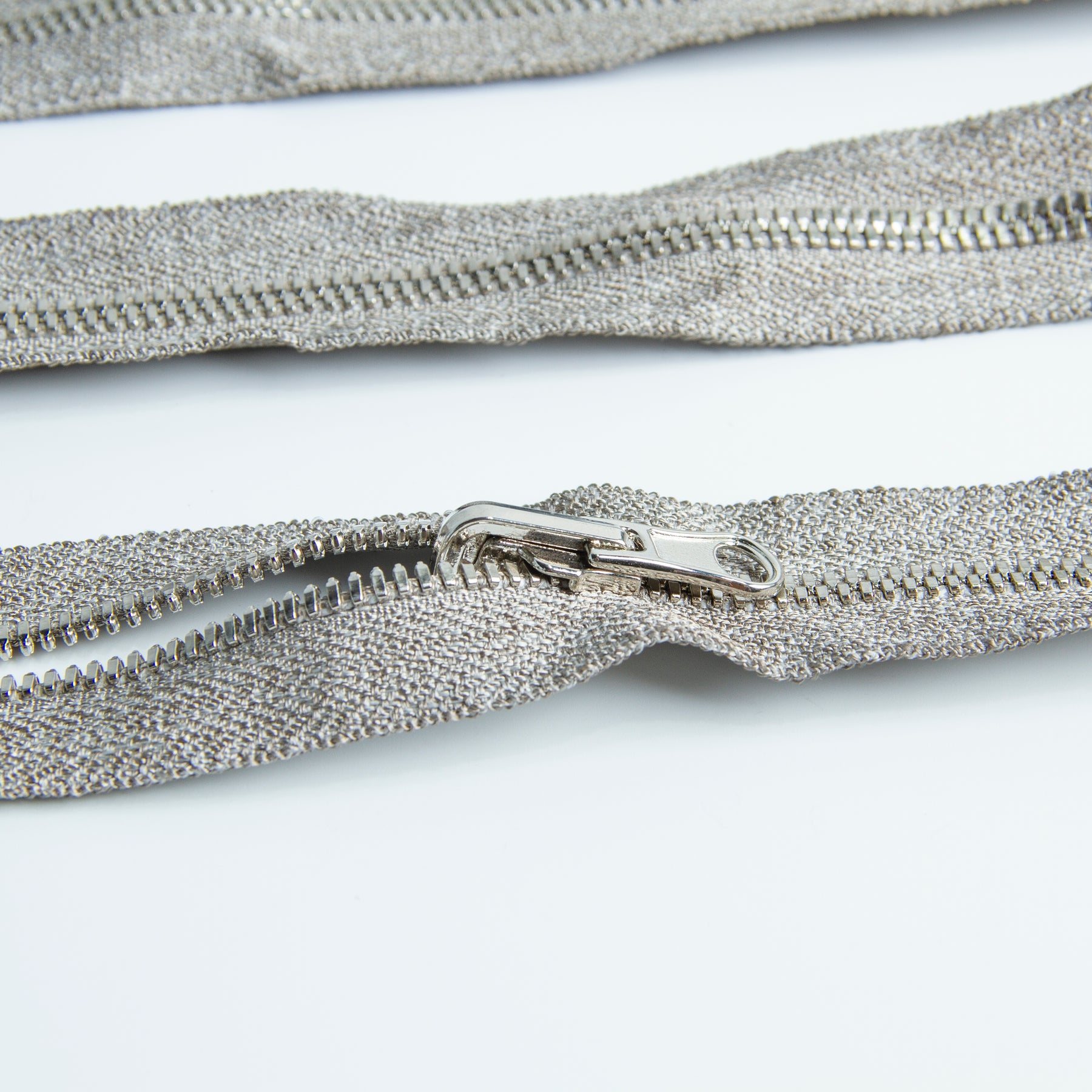 Three Silver Plated Conductive Zippers are parallel with each other
