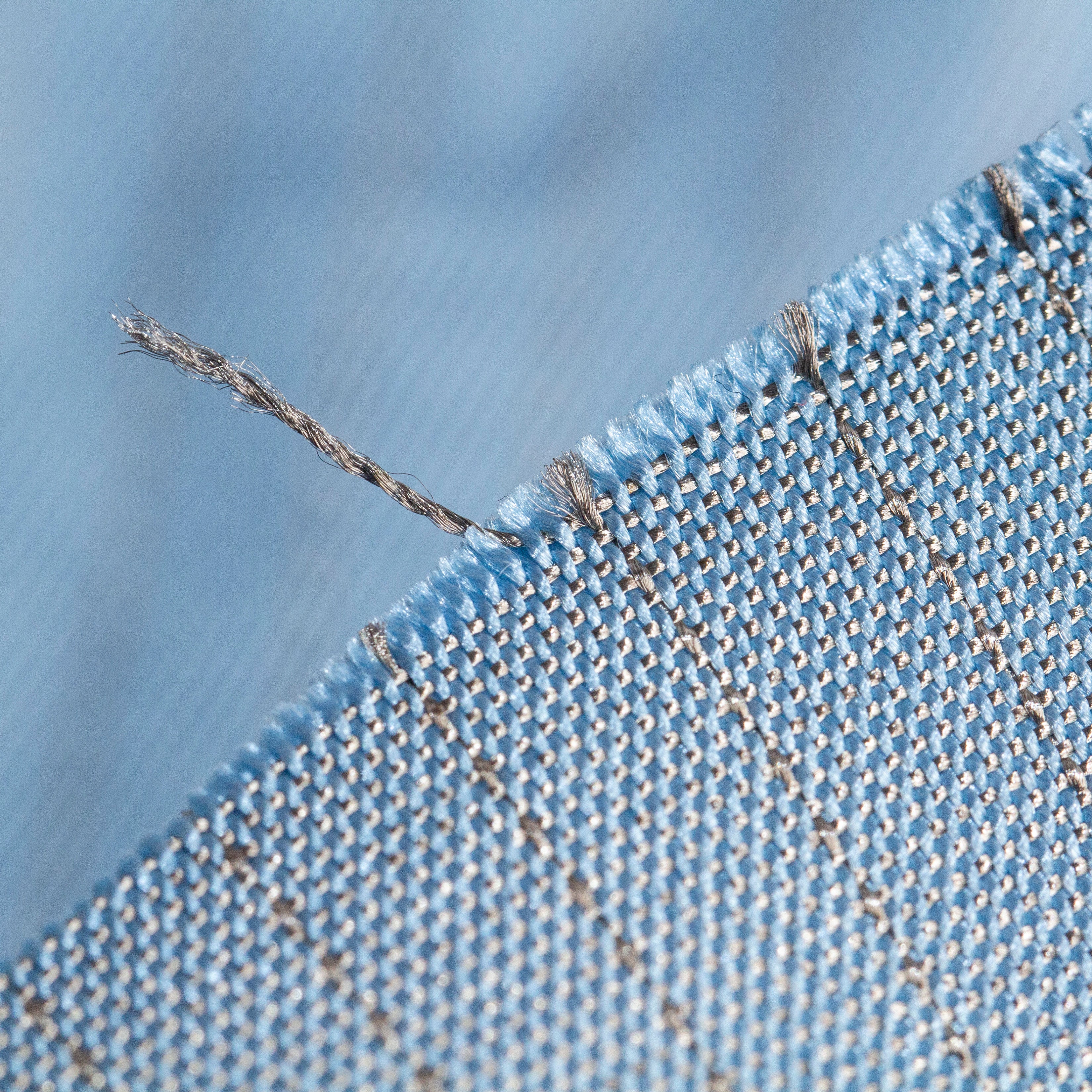 Close view of silver fabric in blue color that designed for fencing lamé jacket