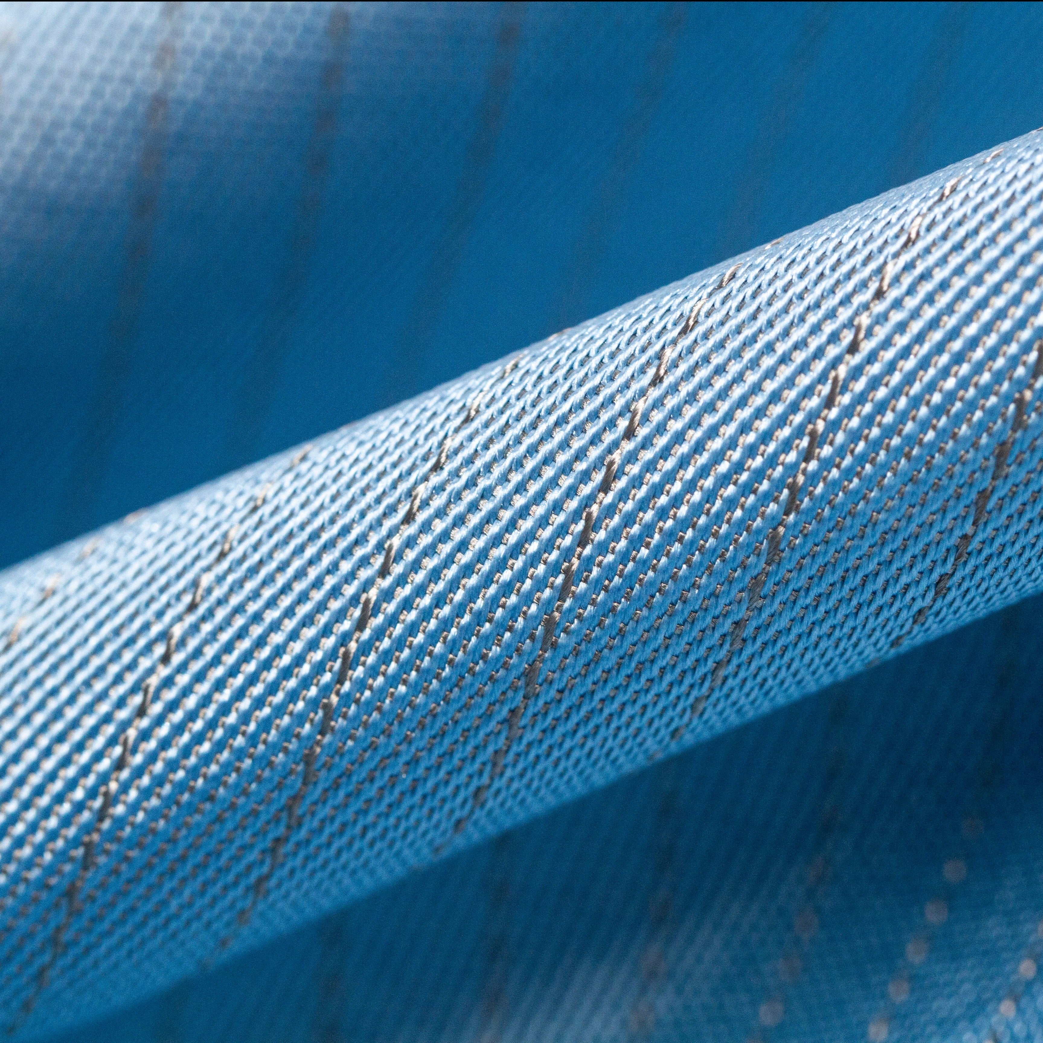 Close view of silver fabric in blue color that designed for fencing lamé jacket. Silver thread weaved with polyester than to have excellent conductivity